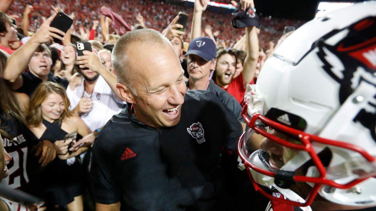 N.C. State head coach Dave Doeren celebrates with quarterback Devin Leary after of N.C. State’s 27-21 overtime victory over Clemson at Carter-Finley Stadium in Raleigh, N.C., Saturday, Sept. 25, 2021.