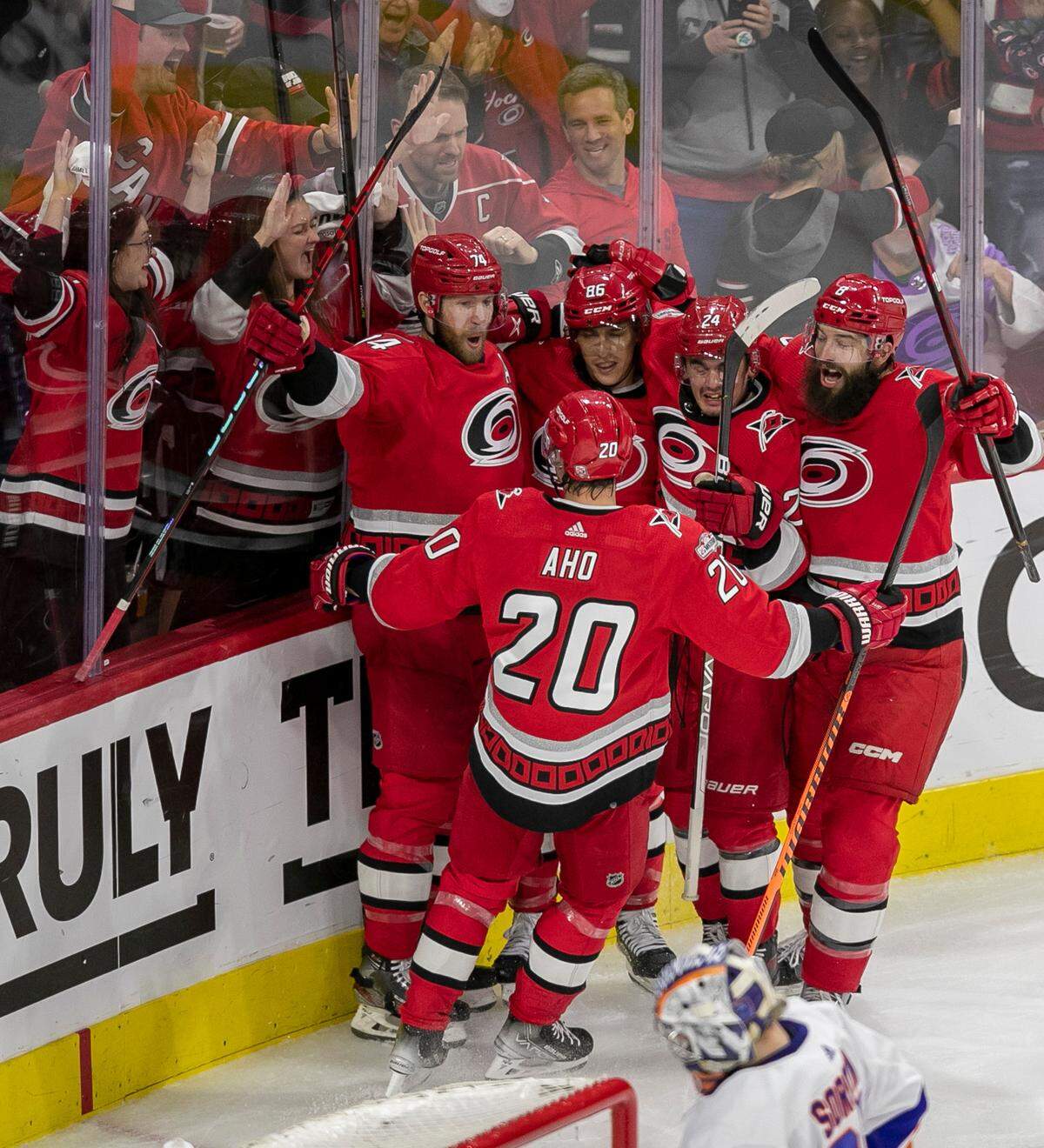Carolina Hurricanes’ Jaccob Slavin (74) is surrounded by teammates after scoring to tie the New York Islanders 3-3 in the third period, forcing overtime during game two of their Stanley Cup series on Wednesday, April 19, 2023 at PNC Arena in Raleigh, N.C.