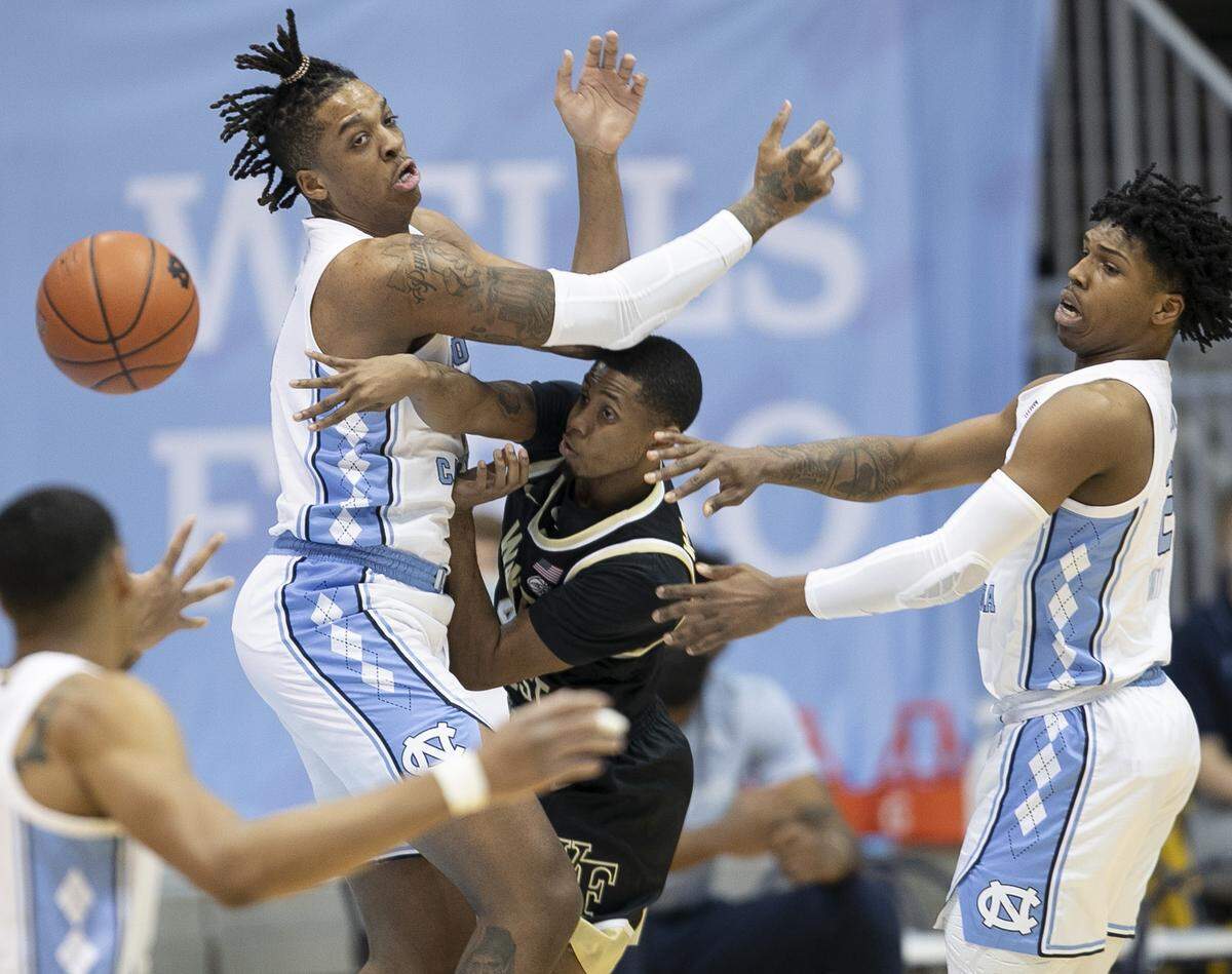 Wake Forest’s Daivien Williamson (4) is trapped by North Carolina’s Armando Bacot (5) and Caleb Love (2) during the first half on Wednesday, January 20, 2021 at the Smith Center in Chapel Hill, NC.