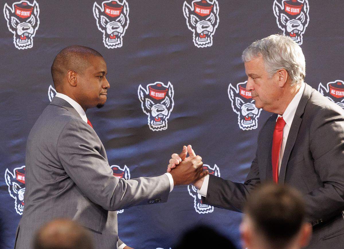 New N.C. State men’s basketball head coach Justin Gainey shakes hands with Athletic Director Boo Corrigan at the start of a press conference at Lenovo Center on Wednesday, April 1, 2026, in Raleigh, N.C.
