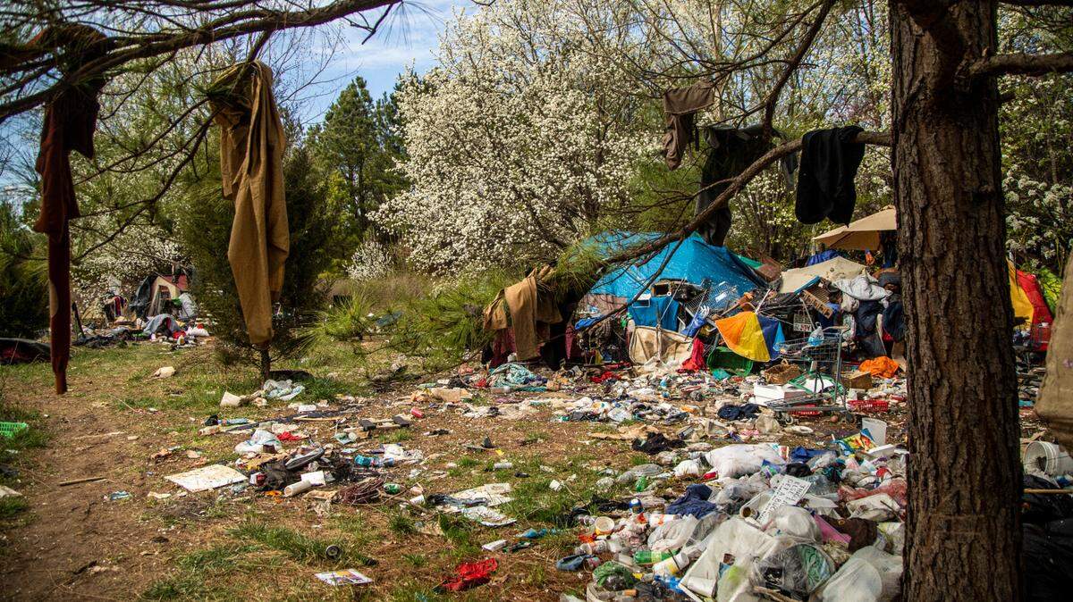 A camp between Interstate 540 and an exit ramp to Capital Boulevard is littered with trash and debris. The NCDOT has received numerous complaints about the site.