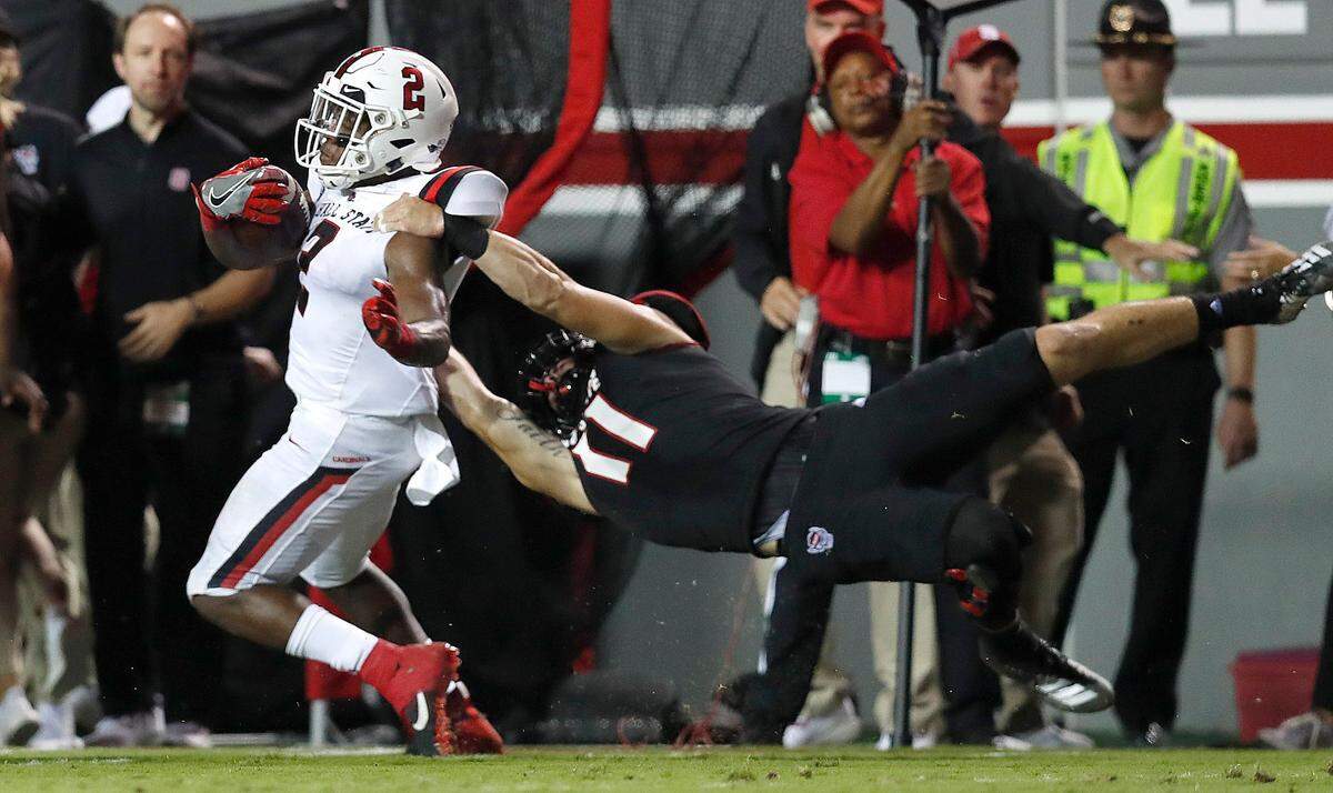 N.C. State linebacker Payton Wilson (11) tackles Ball State running back Caleb Huntley (2) during their game at Carter-Finley Stadium in Sept. 2019.