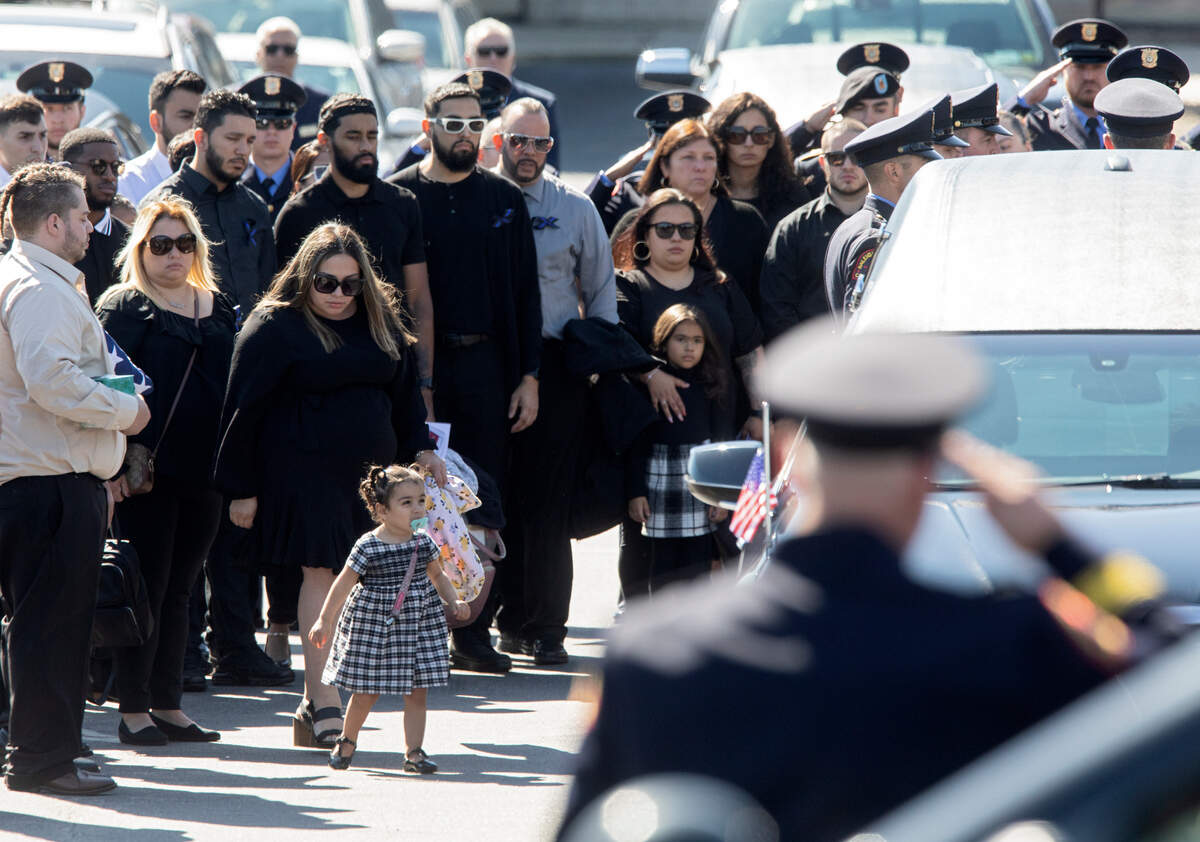 Family stands next to a hearse outside Cross Assembly Church following the funeral of Raleigh police officer Gabriel Torres on Saturday, Oct. 22, 2022, in Raleigh, N.C., Torres, 29, was one of five people fatally shot near the Hedingham neighborhood on Oct. 13.