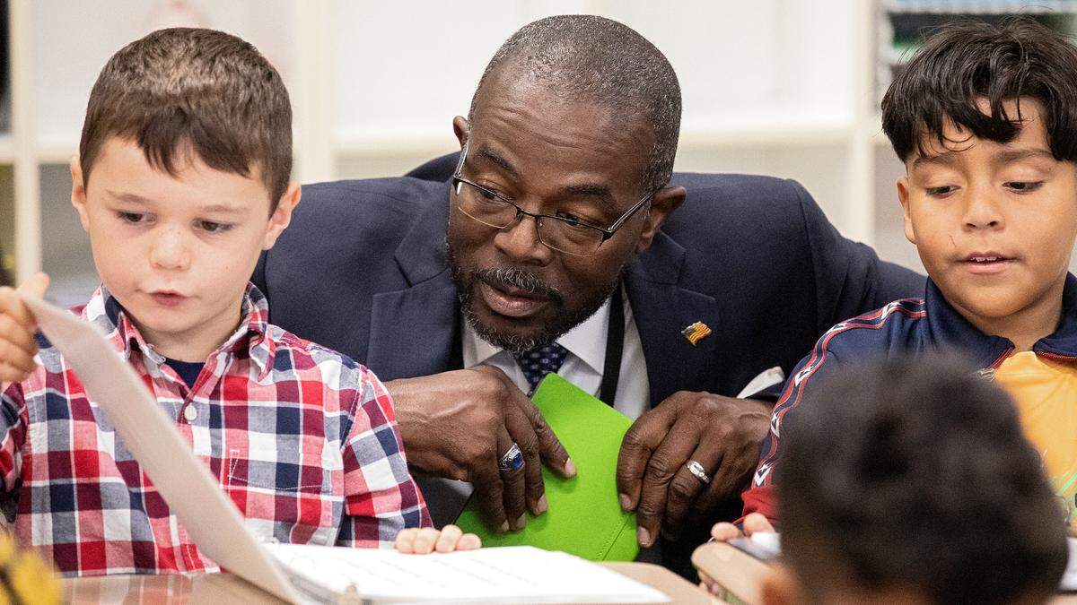New Wake County Superintendent Robert Taylor speaks with second grade students Felix Moss, left, and Cesar Vera Quinones, right, during a tour of Rolesville Elementary School on his first day on the job on Monday, Oct. 2, 2023, in Rolesville, N.C.
