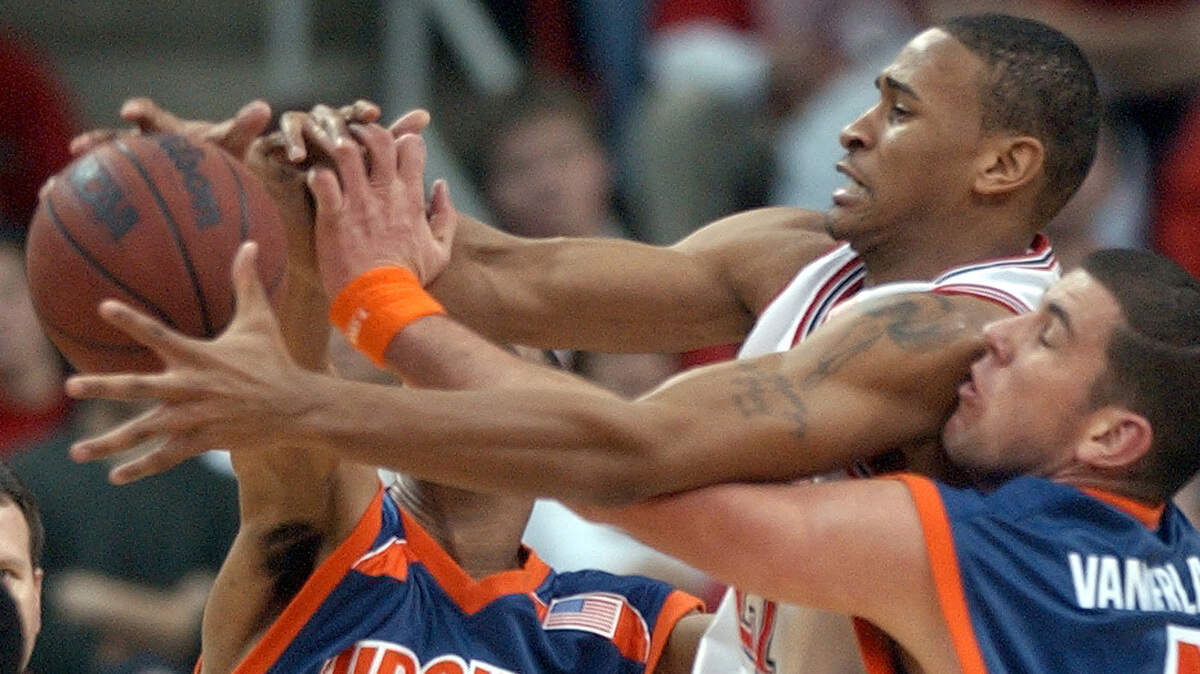 N.C. State’s Levi Watkins fights for a loose ball with Virginia’s Jermaine Harper, left, and Nick Vander Laan during their game in 2003.