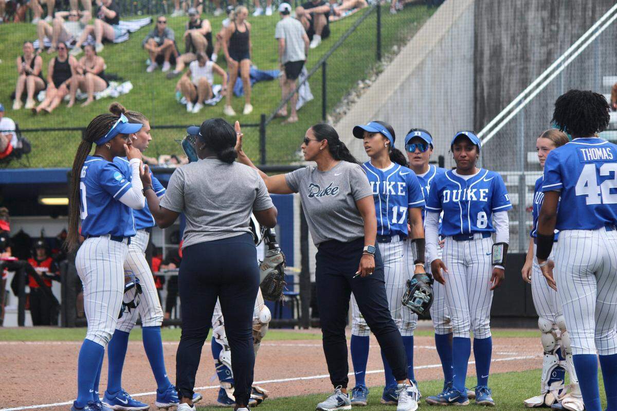 Duke head coach Marissa Young high fives players at the end of an inning during the Blue Devils’ 8-2 NCAA Tournament loss to Georgia on Saturday, May 17, 2025, at Duke Softball Stadium in Durham, N.C.