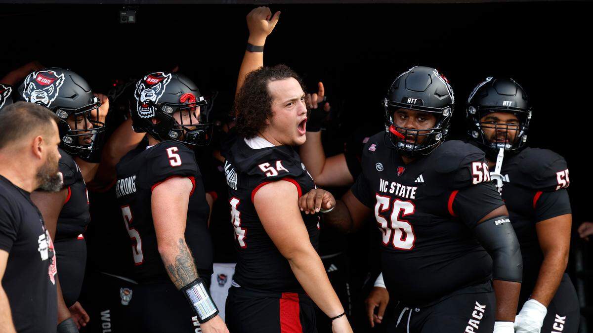 N.C. State offensive lineman Dylan McMahon (54) leads the centers and quarterbacks onto the field to warmup before N.C. State’s game against Louisville at Carter-Finley Stadium in Raleigh, N.C., Friday, Sept. 29, 2023.