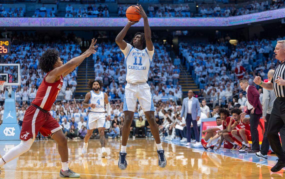 North Carolina guard Ian Jackson (11) launches a three -point shot over Alabama guard Aden Holloway (2) in the first half on Wednesday, December 4, 2024 at the Smith Center in Chapel Hill, N.C.