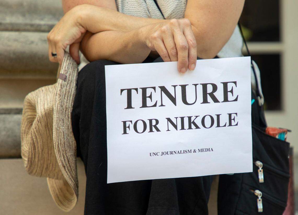 Deborah Dwyer, a doctoral candidate, holds a sign while gathered with fellow students and alumni on the steps of Carroll Hall, where the UNC-Chapel Hill Hussman School of Journalism and Media is located, before the university’s Board of Trustees is scheduled to vote on tenure for distinguished journalist Nikole Hannah-Jones, on Wednesday, Jun. 30, 2021, in Chapel Hill, N.C.