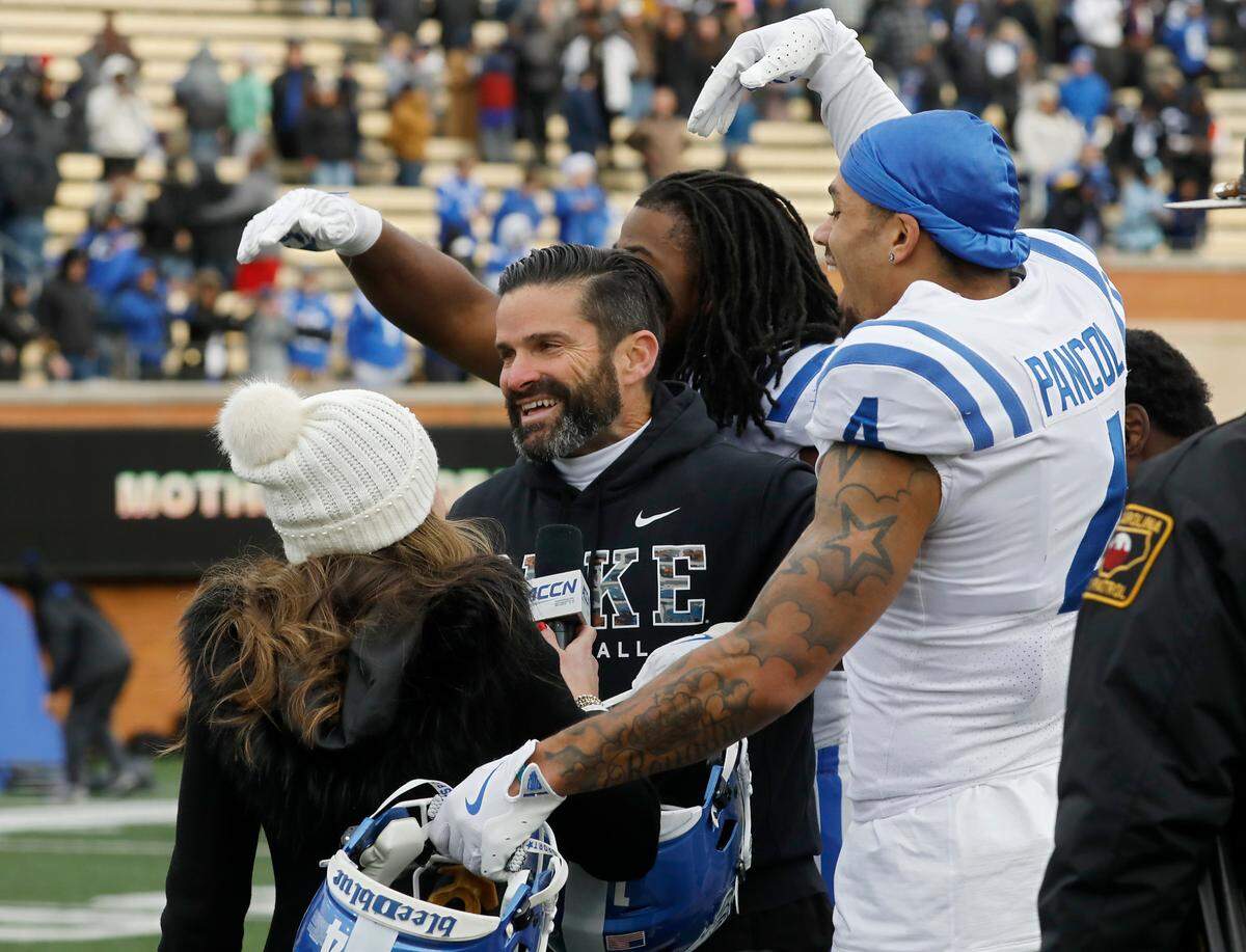 Duke head coach Manny Diaz is swarmed by players following the Blue Devils’ 23-17 win over Wake Forest at Allegacy Stadium on Saturday, Nov. 30, 2024, in Winston-Salem, N.C.