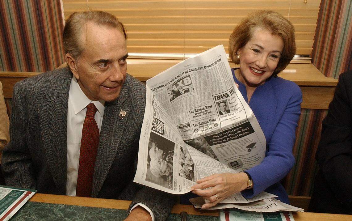 Senator elect Elizabeth Dole laughs and shows off a copy of a local newspaper with the headline about the Republicans winning control of Congress during a lunch with staffers and volunteers in Salisbury in 2002.