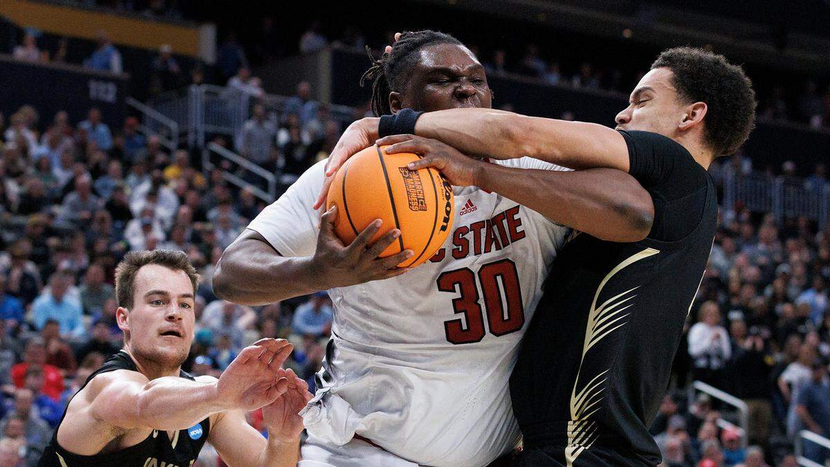 N.C. State’s DJ Burns Jr. drives to the basket against Oakland’s Jack Gohlke and Chris Conway during the second half of the Wolfpack’s 79-73 overtime win in the second round of the NCAA Tournament on Saturday, March 23, 2024, at PPG Paints Arena in Pittsburgh, Pa.