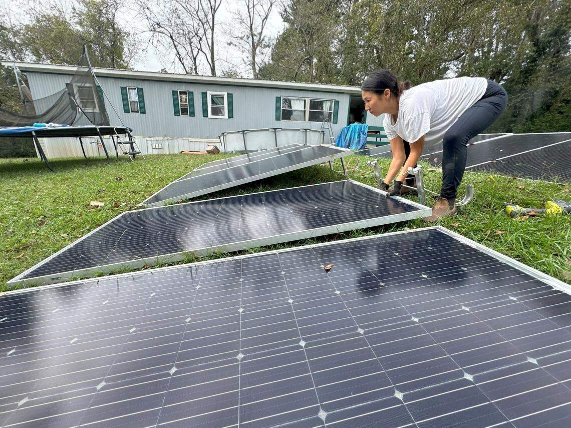 A Footprint Project team member lays down panels in a PODER Emma resident-owned mobile home park just outside of downtown Asheville.
