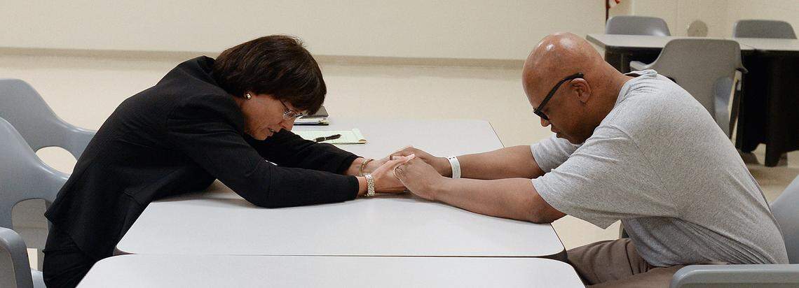 Leon Brown and his attorney his lawyer Ann Kirby recite the Lord’s Prayer after a visit at the Maury Correctional Institution in Maury, N.C. Tuesday, August 26, 2014.