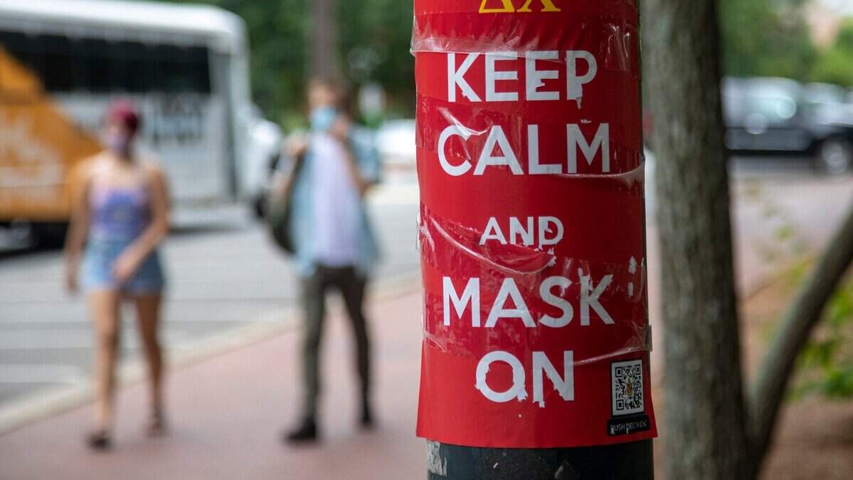 In this 2021 file photo a sign near Kenan Stadium on the UNC-Chapel Hill campus encourages students to wear masks. Orange County is keeping its mask mandate in place for few more weeks. County officials will meet in early March 2022 to reconsider it.