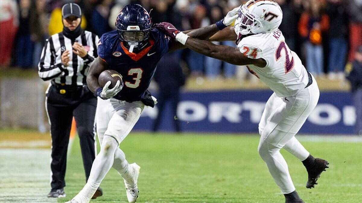 CHARLOTTESVILLE, VIRGINIA - NOVEMBER 29: J'mari Taylor #3 of the Virginia Cavaliers stiff arms Jaden Keller #24 of the Virginia Tech Hokies in the second half during a game at Scott Stadium on November 29, 2025 in Charlottesville, Virginia. (Photo by Ryan M. Kelly/Getty Images)