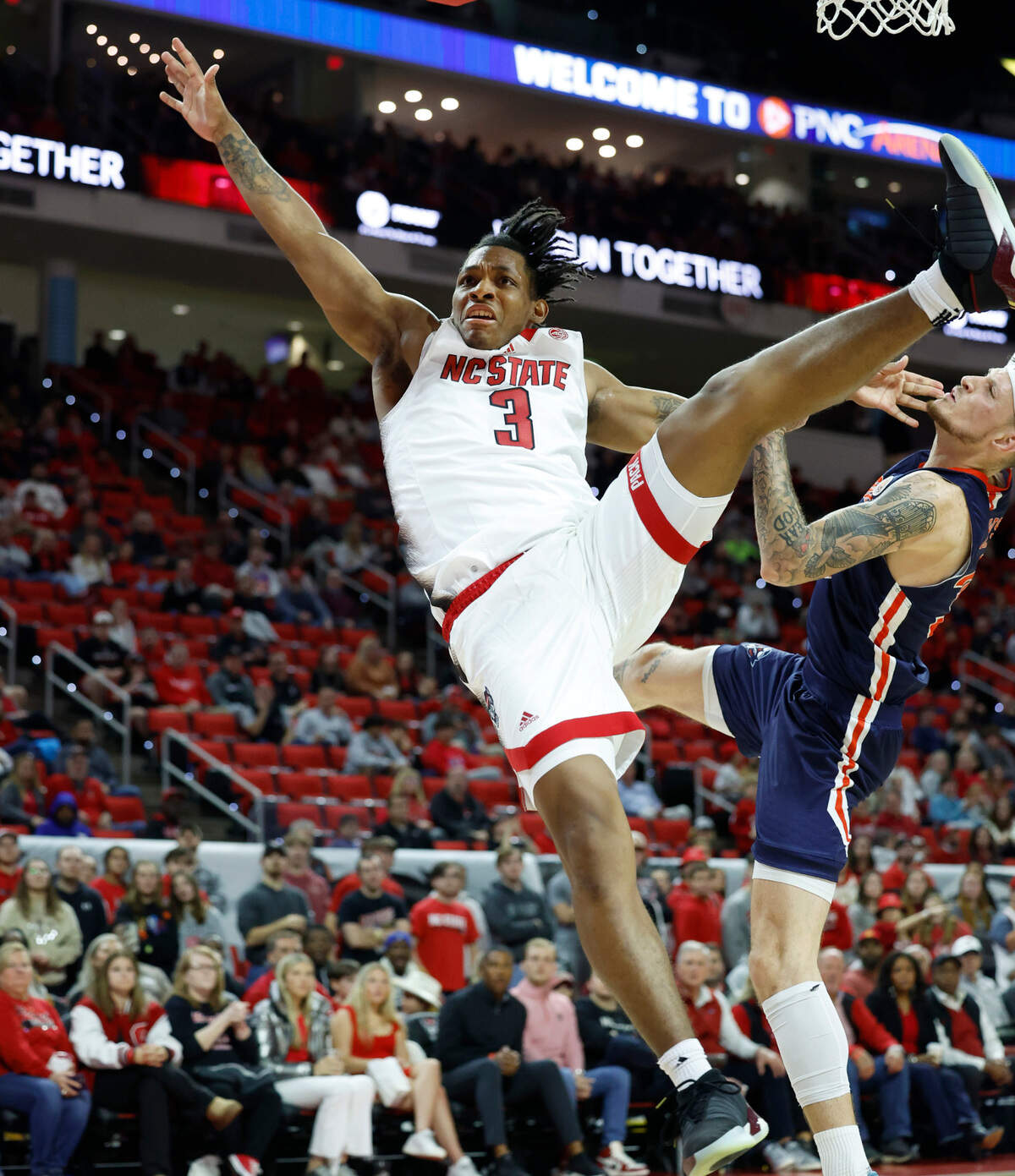 N.C. State’s MJ Rice (3) goes flying after being fouled by UT Martin’s Jacob Crews (35) during the second half of N.C. State’s 81-67 victory over UT Martin at PNC Arena in Raleigh, N.C., Tuesday, Dec. 12, 2023.