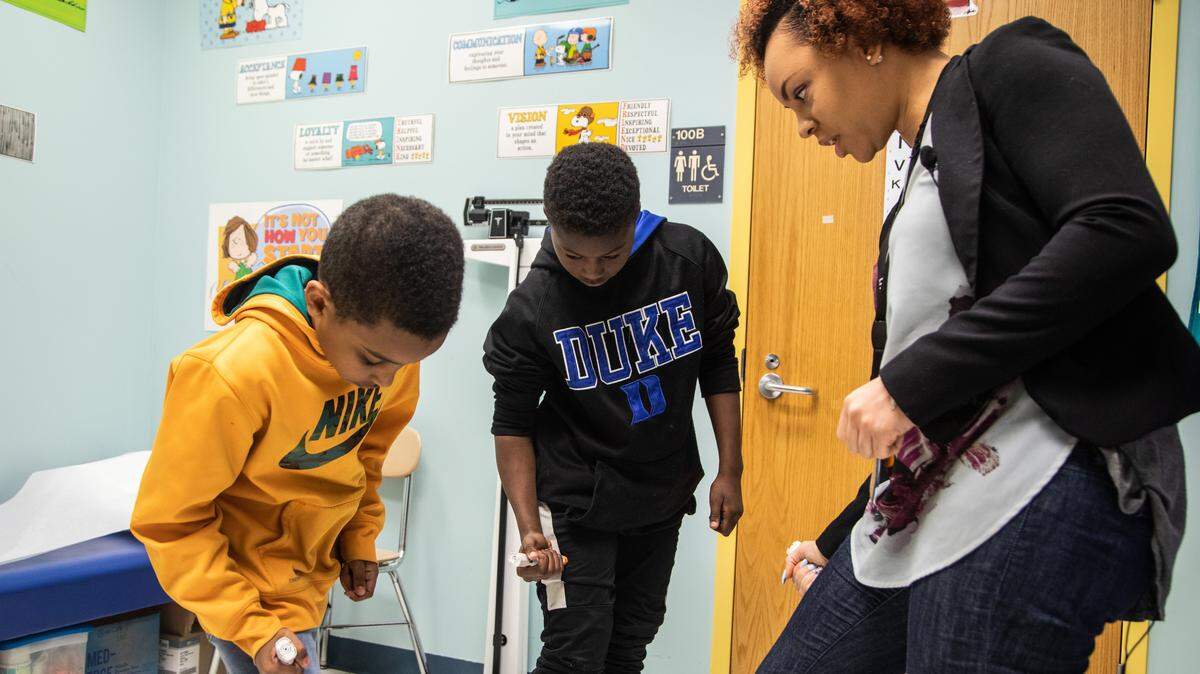 A Wake County school nurse reviews proper Epipen procedures with two students at Dillard Drive Elementary School in 2018. The N.C. House has approved a bill that would allow more people to serve as school nurses.