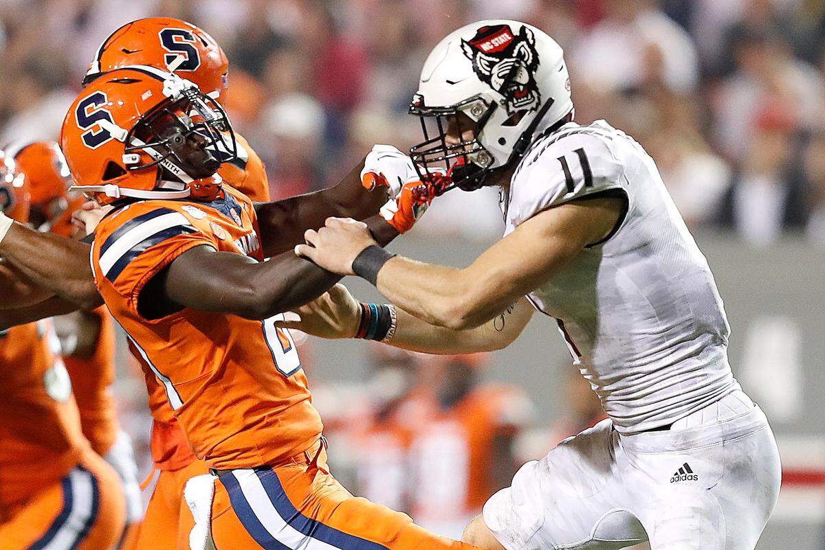 Syracuse’s Cameron Jordan (81) grabs onto the helmet of N.C. State’s Payton Wilson (11) during a kickoff in the Wolfpack’s 16-10 victory over Syracuse in October 2019.