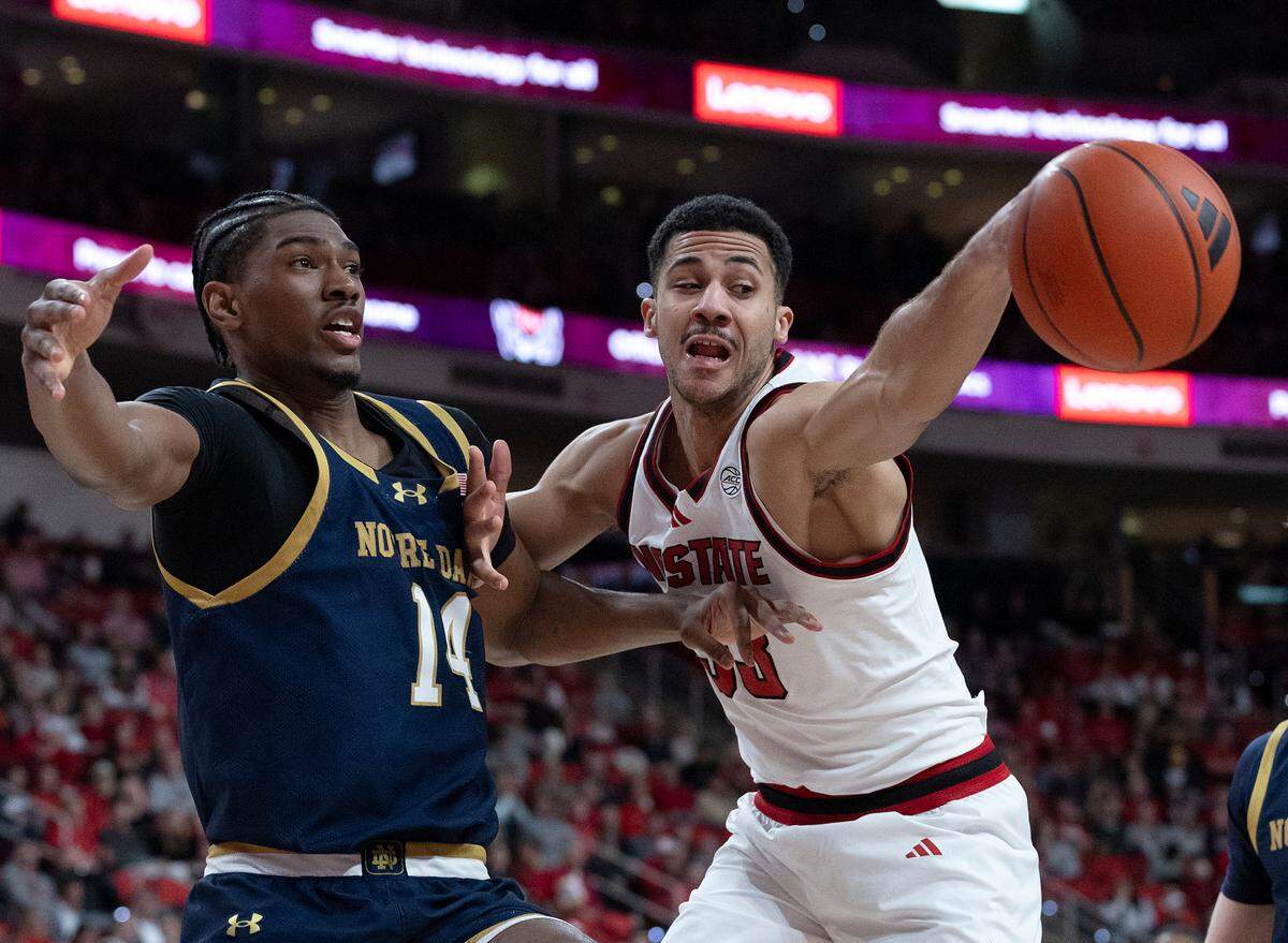 Notre Dame’s Kebba Njie and N.C. State’s Ismael Diouf battle for a loose ball during the first half of the Wolfpack’s 66-65 win on Wednesday, Jan. 8, 2025, at Lenovo Center in Raleigh, N.C.