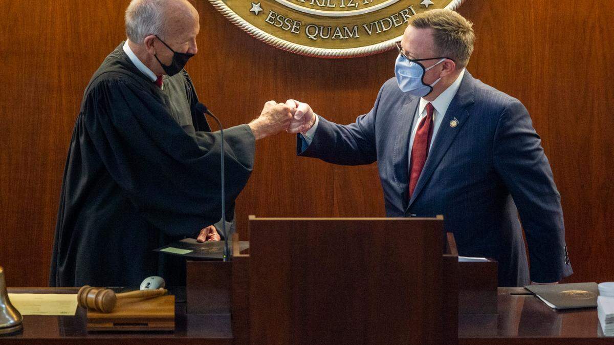 Chief Justice Paul Newby, left, fist bumps House Speaker Tim Moore Wednesday, Jan. 13, 2021, at the North Carolina General Assembly.