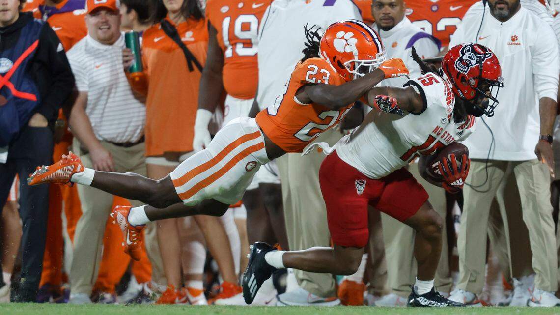 N.C. State wide receiver Keyon Lesane (15) tries to escape from Clemson cornerback Toriano Pride (23) during the second half of Clemson’s 30-20 victory over N.C. State at Memorial Stadium in Clemson, S.C., Saturday, Oct. 1, 2022.
