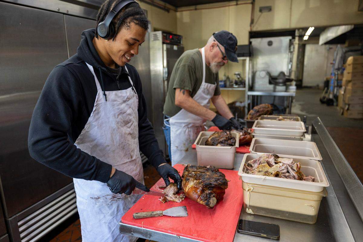 Nkosi Barnes and Bill Link break apart cooked pork shoulders at Lexington Barbecue on Tuesday, October 10, 2023 in Lexington, N.C.
