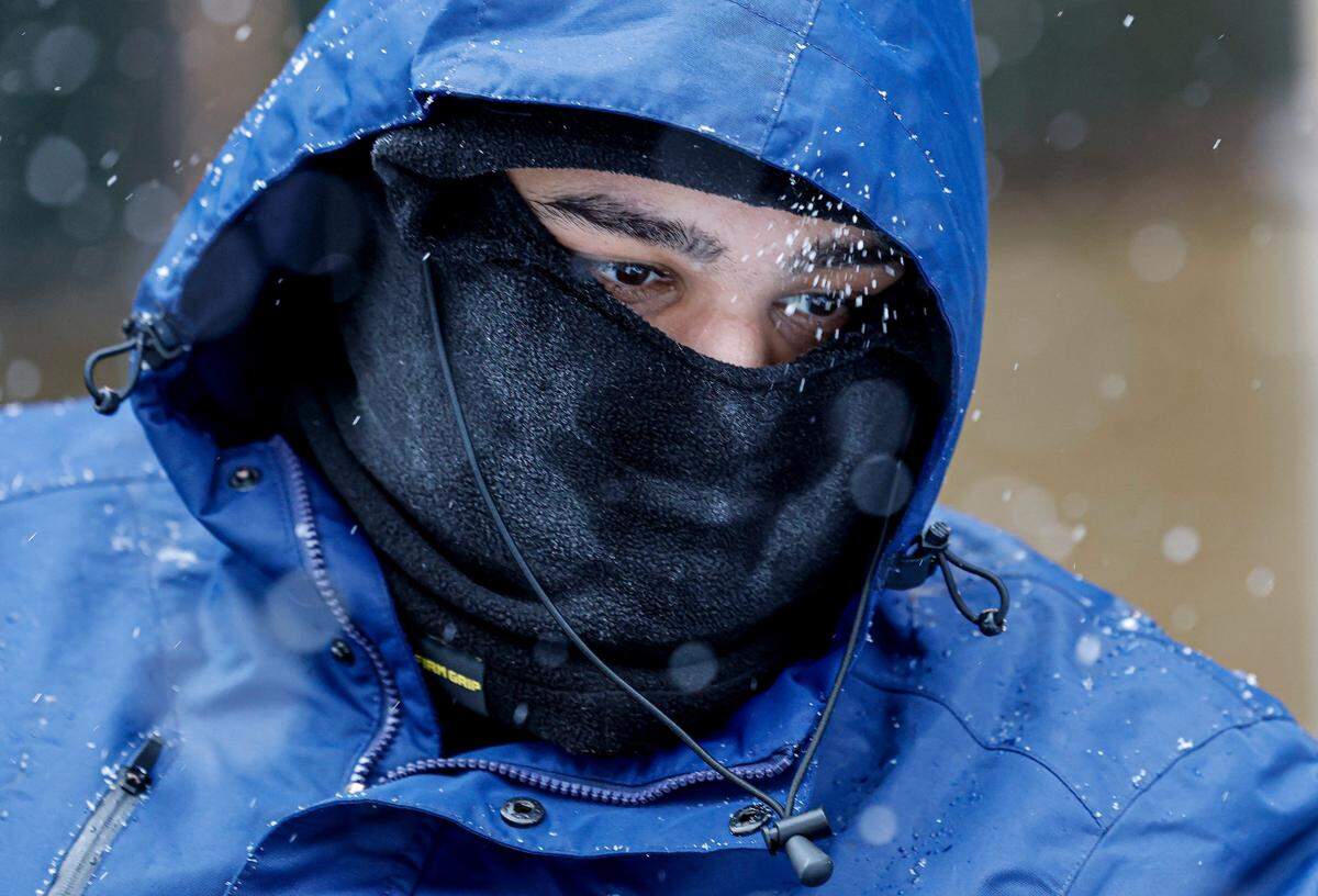 Nidhal Benyahia with Highwoods Properties clears the snow and slush from an entrance to 150 Fayetteville in downtown Raleigh early Wednesday afternoon, Feb. 19, 2025.
