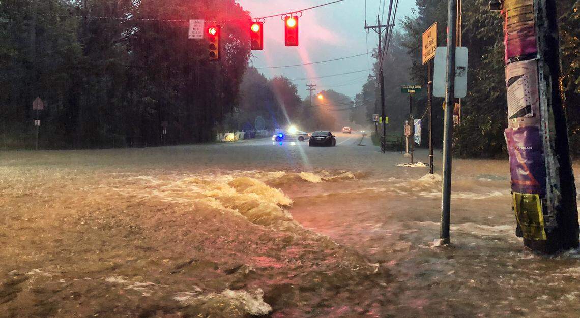 Flood waters surge through the intersection of Estes Drive Extension and Greensboro Street in Carrboro, NC Monday morning as heaving rains moved through the area.