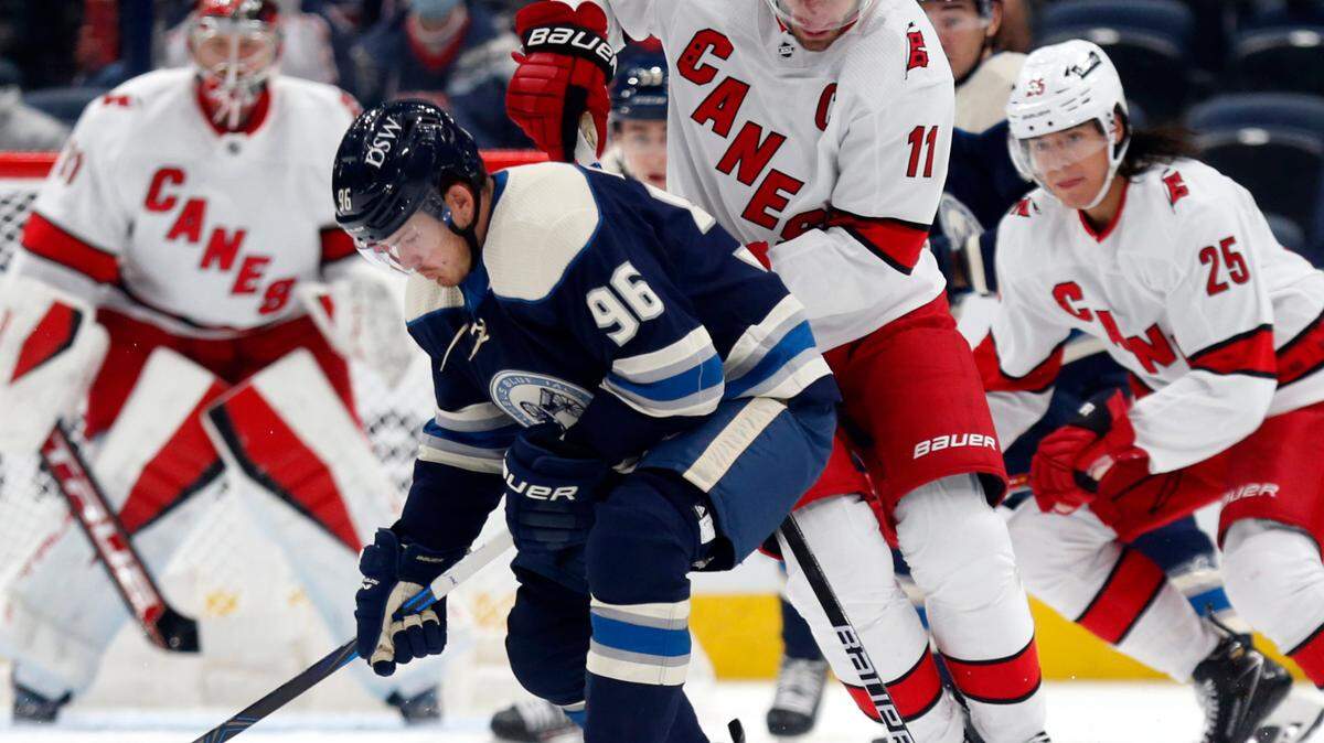 Columbus Blue Jackets forward Jack Roslovic, front left, controls the puck in front of Carolina Hurricanes forward Jordan Staal during the first period of an NHL hockey game in Columbus, Ohio, Saturday, Oct. 23, 2021. (AP Photo/Paul Vernon)