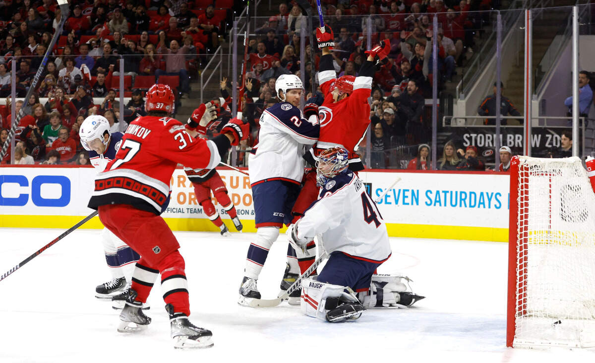 Carolina’s Jesperi Kotkaniemi (82), center, and Andrei Svechnikov (37) celebrate after Brady Skjei scored during the second period of the Carolina Hurricanes game against the Columbus Blue Jackets at PNC Arena in Raleigh, N.C., Wednesday, Oct. 12, 2022.