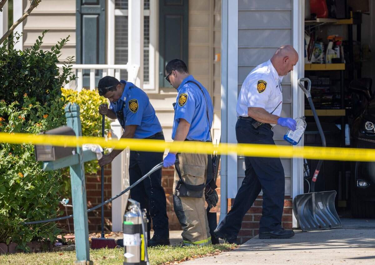 Raleigh Firemen clean the porch and sidewalk at 5355 Sahalee Way on Friday, October 14, 2022 in Raleigh, N.C., after the killing of five people yesterday in the Hedingham neighborhood including an off-duty police officer.