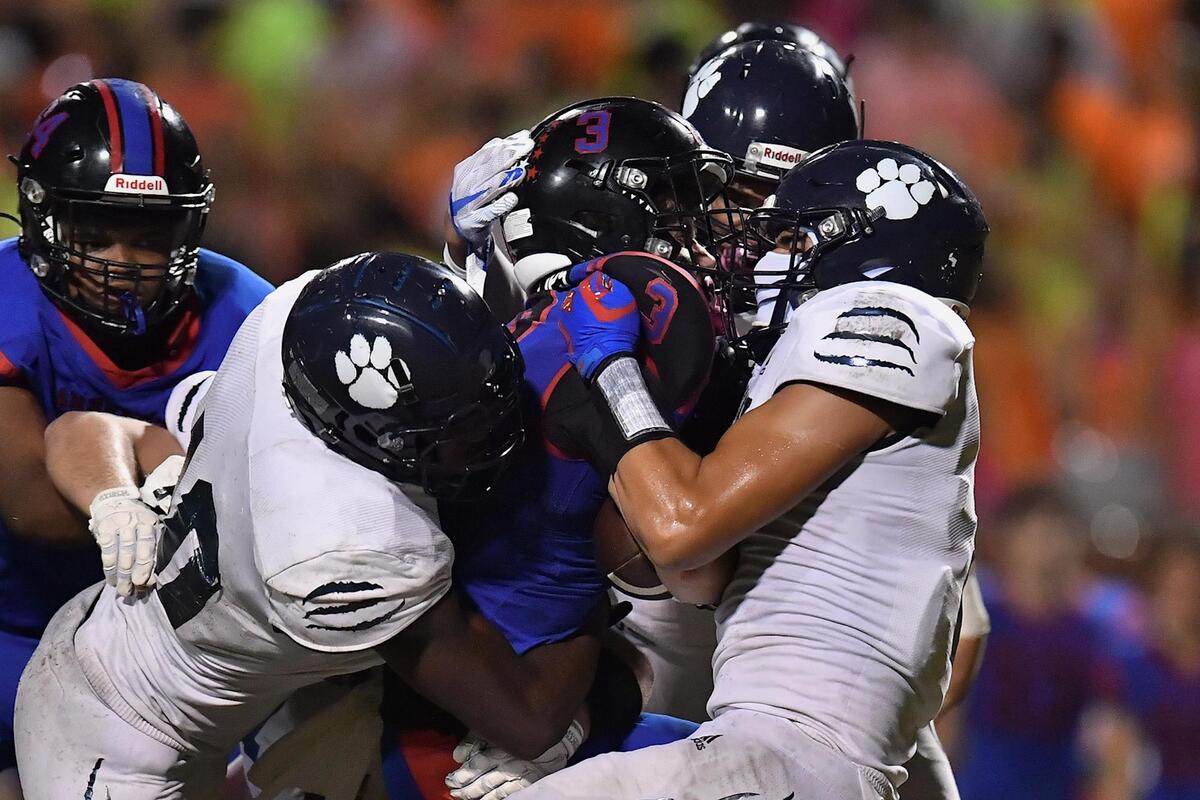 Millbrook defense takes down Sanderson’s Busbee Phillips (3) during the second half. The Sanderson Spartans and the Millbrook Wildcats met in a football game in Raleigh, N.C. on September 16, 2022.