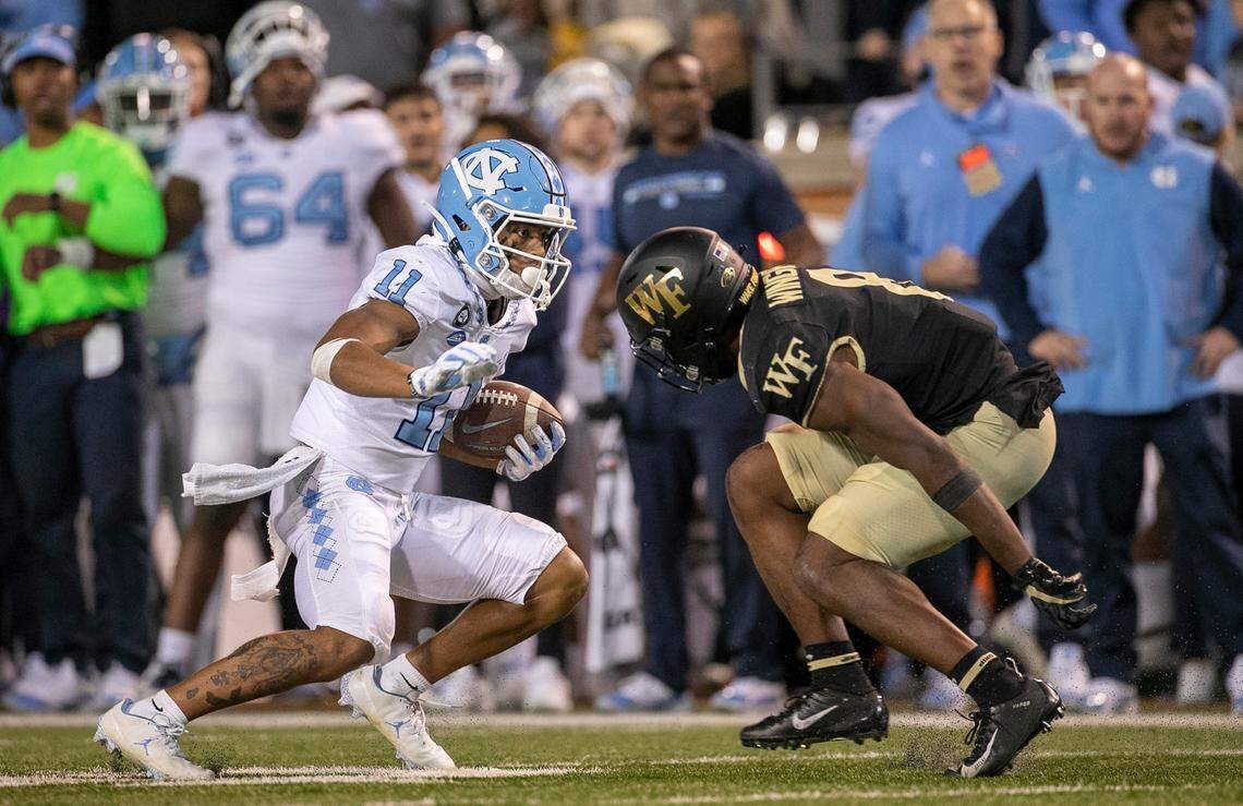 North Carolina’s Josh Downs (11) looks for running room against Wake Forest’s Isaiah Wingfield (8) after a 43-yard pass reception from quarterback Drake Maye in the fourth quarter on Saturday, November 12, 2022 at Truist Field in Winston-Salem, N.C.