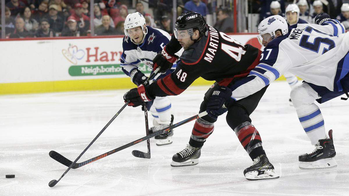 Carolina Hurricanes’ Jordan Martinook (48) tries to shoot while Winnipeg Jets’ Tyler Myers (57) and Dmitry Kulikov (5), of Russia, defend during the first period of an NHL hockey game in Raleigh, N.C., Friday, March 8, 2019.