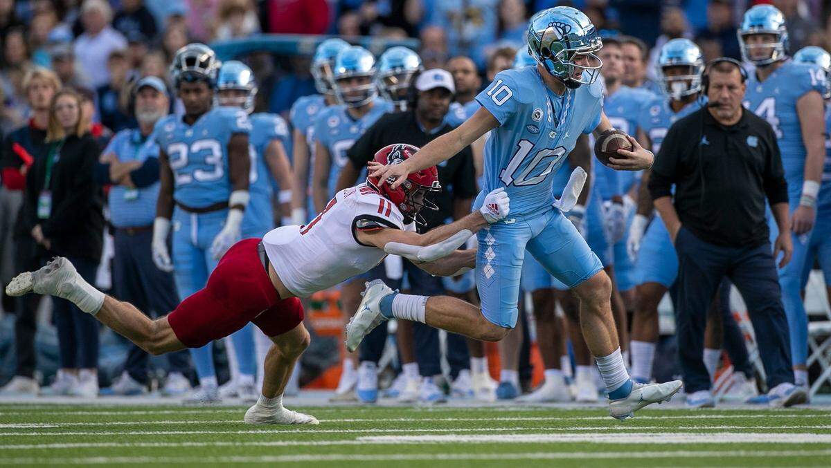 N.C. State’s Payton Wilson (11) chases North Carolina quarterback Drake Maye (10) out of bounds during their game at Kenan Stadium in Nov. 2022.