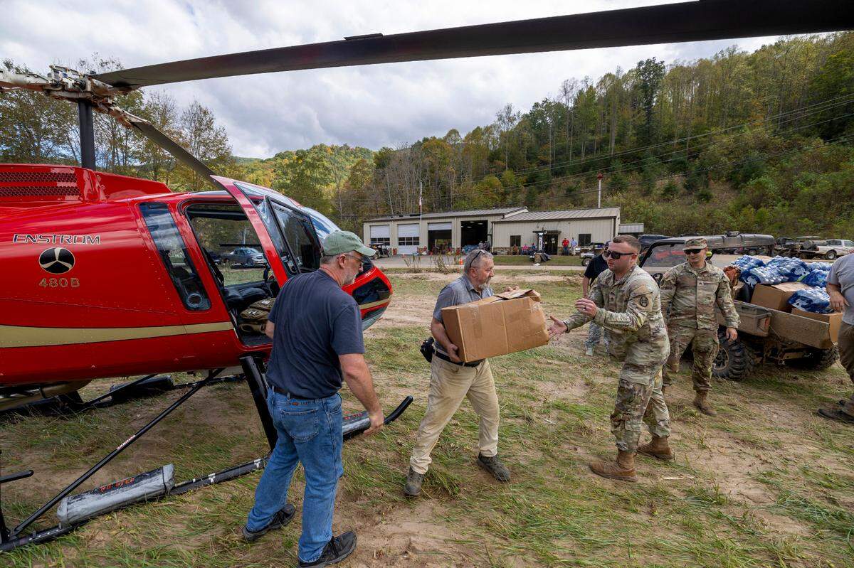 Mark Harrison, Chief Medical Officer for the Pensacola Fire Department, center, unloads supplies from Helicopter pilot Brett James, with Willow Creek Aviation of Louisburg, N.C., on Thursday, October 3, 2024 in Pensacola, N.C.