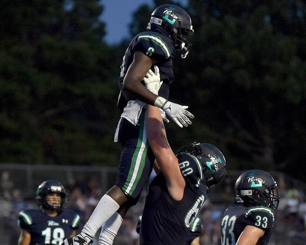 Leesville Road’s Tim Hogan (60) hoists up and celebrates with Nasir Winston (6) after his touchdown during the second quarter. The Leesville Pride and the Panther Creek Catamounts met in a football game in Raleigh, N.C. on August 27, 2021.
