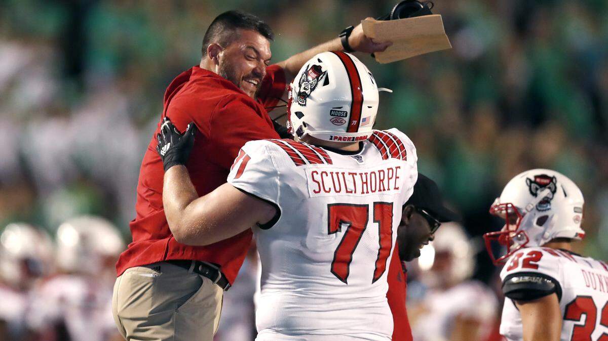 N.C. State’s Joe Sculthorpe (71) celebrates with offensive line coach Dwayne Ledford during the first half of N.C. State’s game against Marshall at Joan C. Edwards Stadium at Marshall University in Huntington, West Virginia Saturday, Sept. 22, 2018.