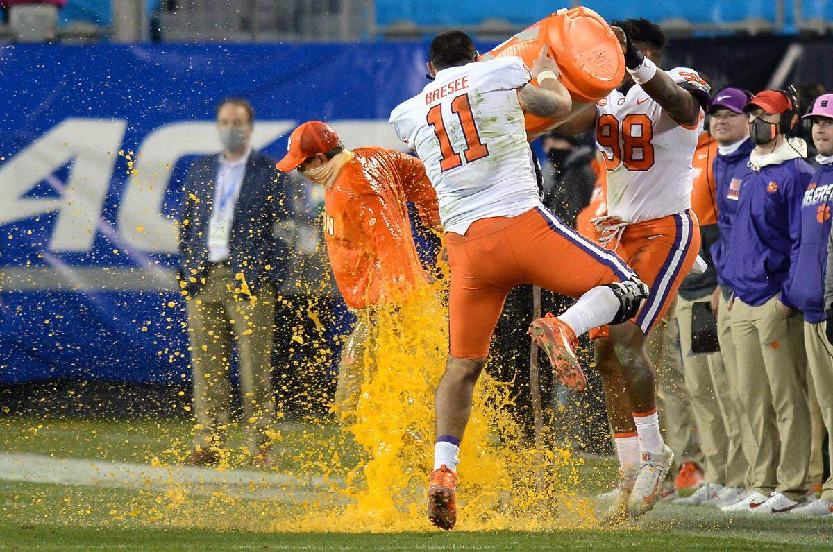 Clemson Tigers head coach Dabo Swinney, left, receives a gatorade bath in the closing moments of the ACC Championship game. Clemson defeated Notre Dame 34-10 to win the championship at Bank of America Stadium in Charlotte, NC on Saturday, December 19, 2020.  