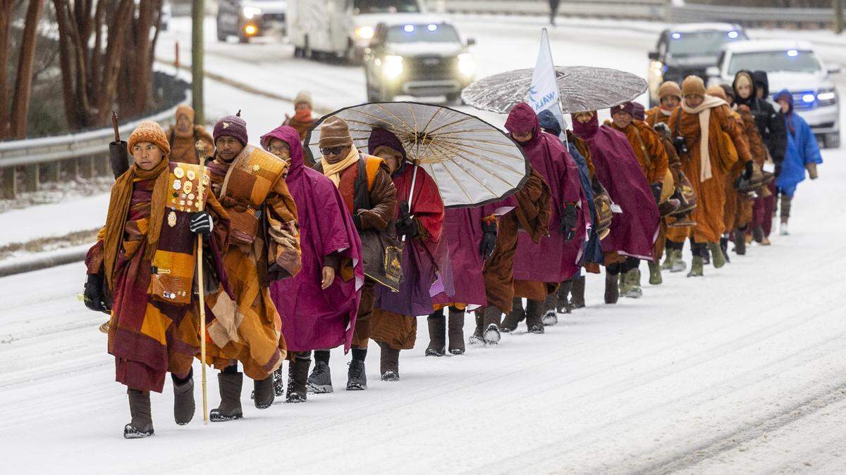 A procession of Buddhist monks walks along snow-covered Raleigh Boulevard in Raleigh, N.C. on Sunday morning, Jan. 25, 2026. The monks are making a 2,300-mile pilgrimage from Texas to Washington, D.C., as part of the Walk for Peace, an effort to promote peace, compassion and national unity.