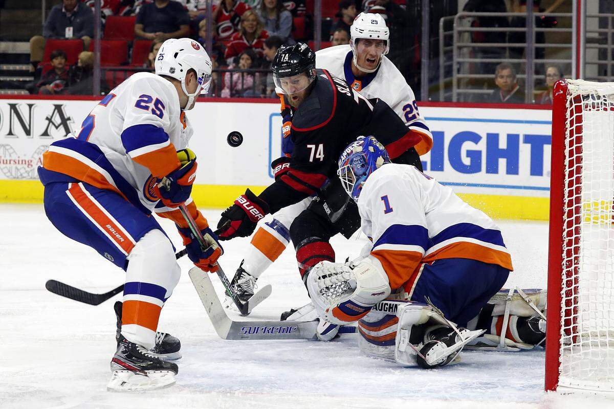 Carolina Hurricanes’ Jaccob Slavin (74) battles between New York Islanders’ Devon Toews (25), Brock Nelson (29) and goaltender Thomas Greiss (1), of Germany, during the second period of an NHL hockey game, in Raleigh, N.C., Friday, Oct. 11, 2019. (AP Photo/Karl B DeBlaker)