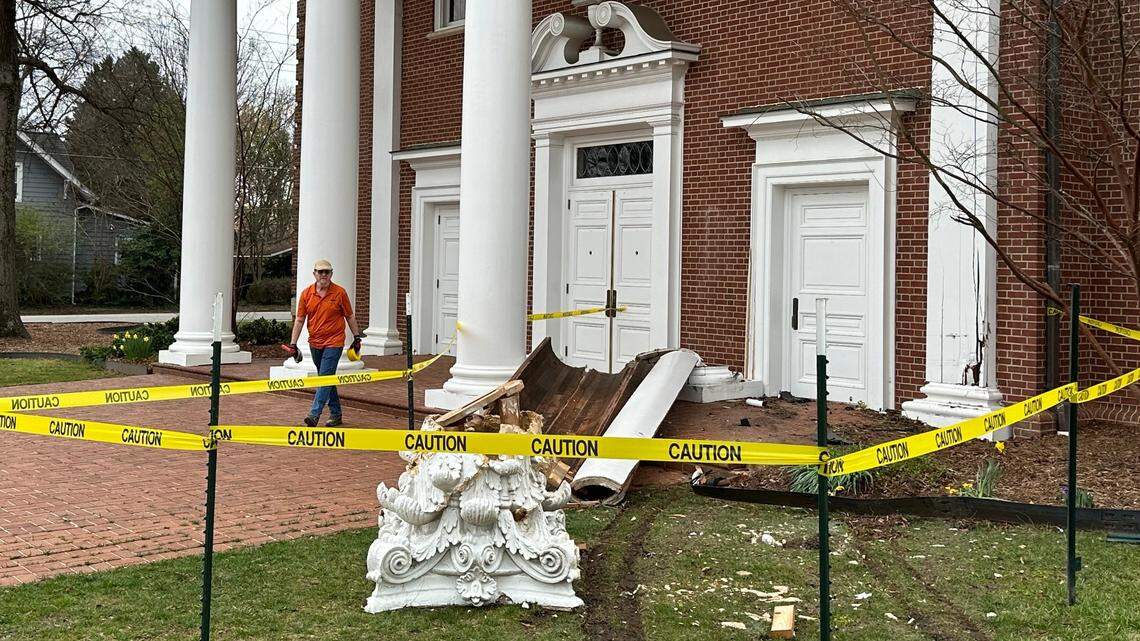 Steve Komnath, director of facilities services for Forest Hills Baptist Church in Raleigh, finishes putting up safety tape around a column that collapsed when it was hit by a car on Tuesday evening.