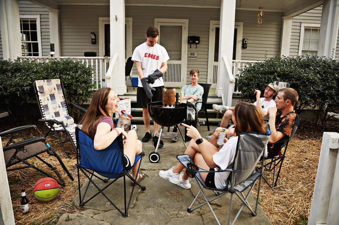 A group of friends and siblings, from left, Laurel Hunt, Thomas Neuenschwander, Will Adams, Jon Matson, Peter Neuenschwander and Rebecca Mennard come together for a barbecue Friday evening, March 20, 2020, in downtown Raleigh to enjoy the spring weather. Out of the group, some are working from home or taking classes online while others still have to report to work in-person.
