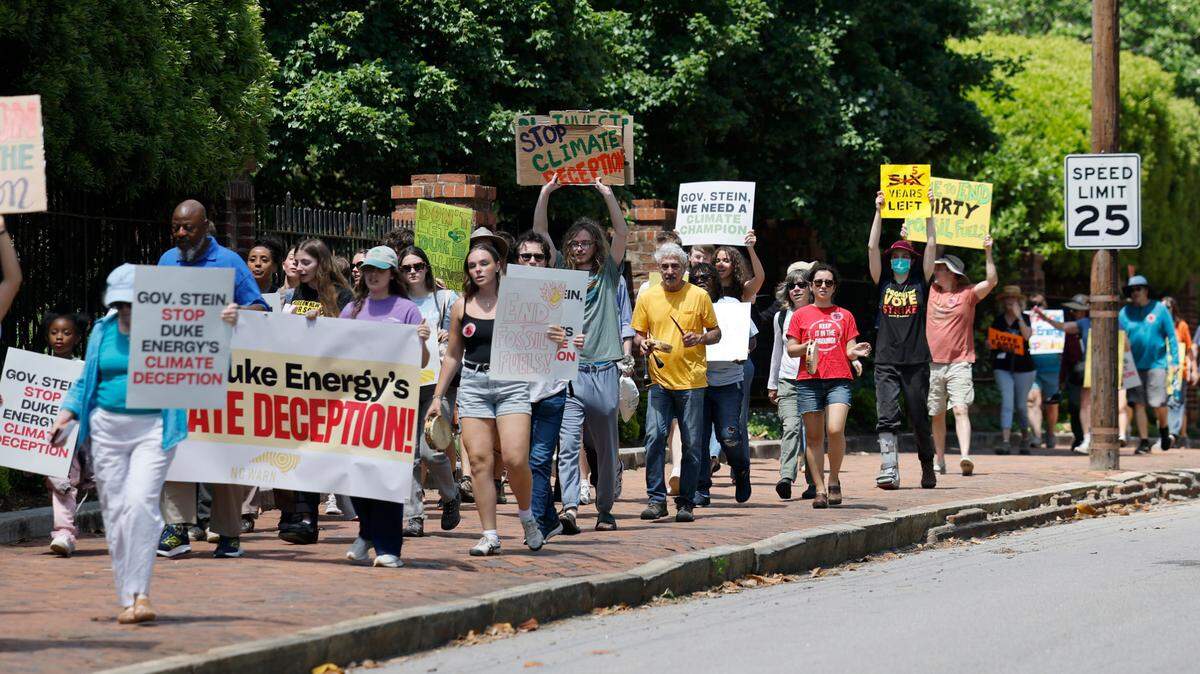 Protesters walk around the N.C. Executive Mansion during a rally and march organized by NC WARN in Raleigh, N.C., Saturday, April 26, 2025. About 85 people gathered to pressure Gov. Josh Stein to speak out against Duke Energy and push the state’s monopoly utility to embrace renewable energy.