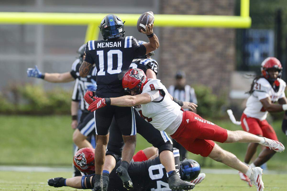 Duke quarterback Darian Mensah (10) gets off the throw as he is being hit by N.C. State’s Cian Slone (8) during the first half of N.C. State’s game against Duke at Wallace Wade Stadium in Durham, N.C., Sat. Sept. 20, 2025