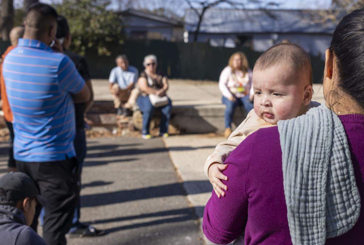 Eva Oseduera holds her four-month-old son Otonell Oseduera as they listen to Katia Roebuck, with the NC Congress of Latino Organizations, during a meeting with residents of Chatham Estates Mobile Home Park on Wednesday, December 24, 2025 in Cary, N.C. Oseduera and her family are concerned they will have to move from their home soon after rumors of eviction notices have spread through their neighborhood.