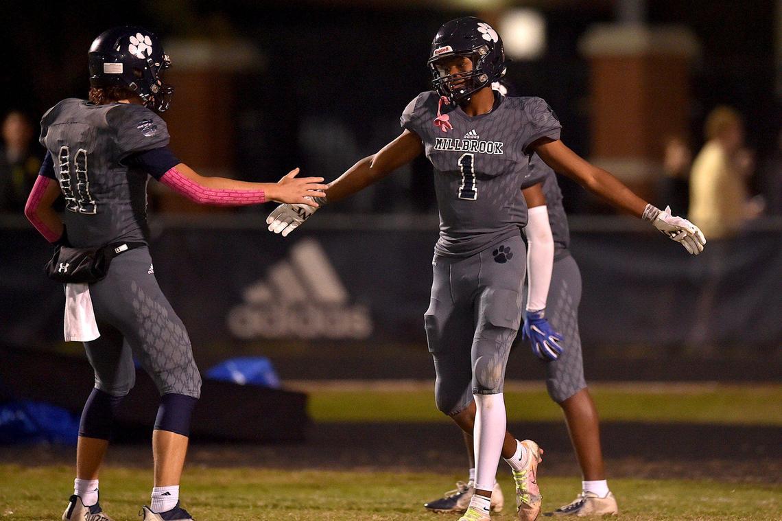 Millbrook’s Wesley Grimes (1) is congratulated by quarterback Mason Fortune (11) after his touchdown in the fourth quarter.The Millbrook Wildcats and the Wake Forest Cougars met in a football game in Raleigh, N.C. on October 29, 2021.