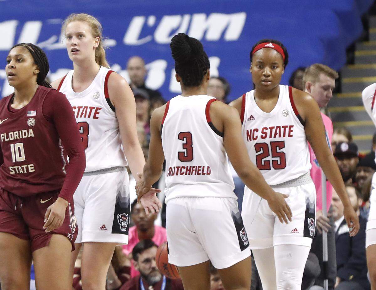 N.C. State’s Kai Crutchfield (3) talks with Elissa Cunane (33) and Kayla Jones (25) as they come up the court during the Wolfpack’s 71-66 victory over the Florida State Seminoles in the ACC Tournament finals at Greensboro Coliseum in Greensboro, N.C., Sunday, March 8, 2020.