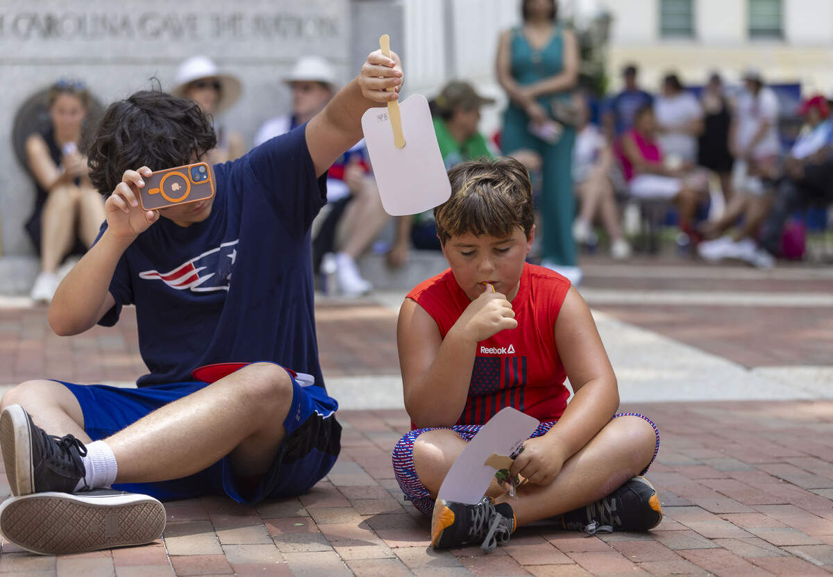 With temperatures nearing the triple digit mark, Johnathan Thatcher fans Joseph Gavazzi during the Freedom Fest 250, celebrating the country’s Semiquincentennial, at the North Carolina State Capitol, on Saturday, July 4, 2026 in Raleigh, N.C.